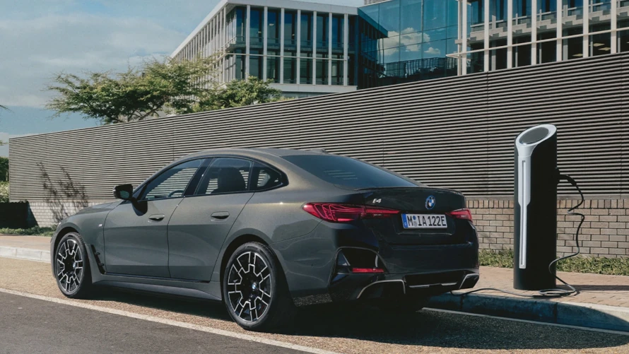 Elektrisches Auto auf einem Parkplatz mit modernen Gebäuden im Hintergrund.